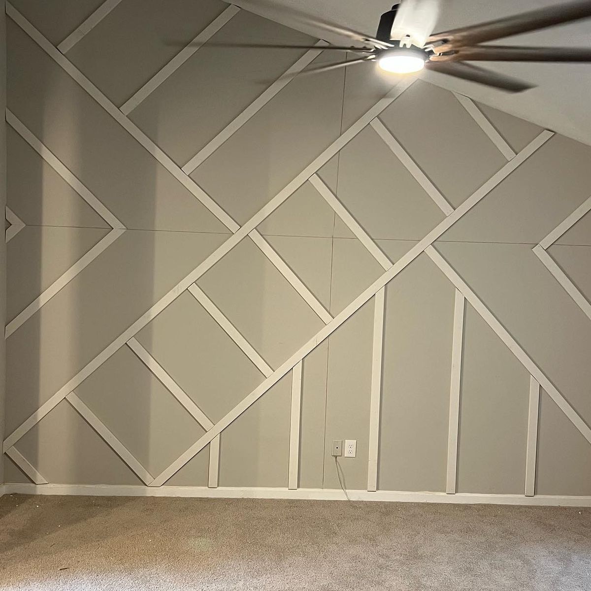 Before: a gray wall with geometric white trim installed
