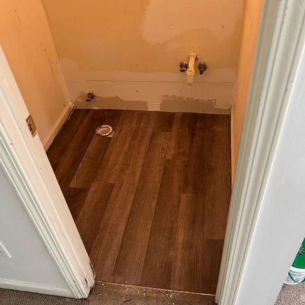 New plank flooring laid in a half bath before the fixtures go in