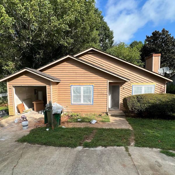 Before: a house with faded tan siding